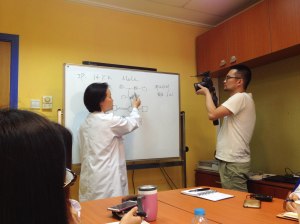 Dr. Ji, director of the Social Work Department at Shanghai Children's Medical Center, discussing a case as a cameraman films for an upcoming TV documentary about social workers in Shanghai.